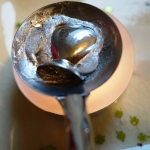 Heart metal figure on spoon being melted over a candle